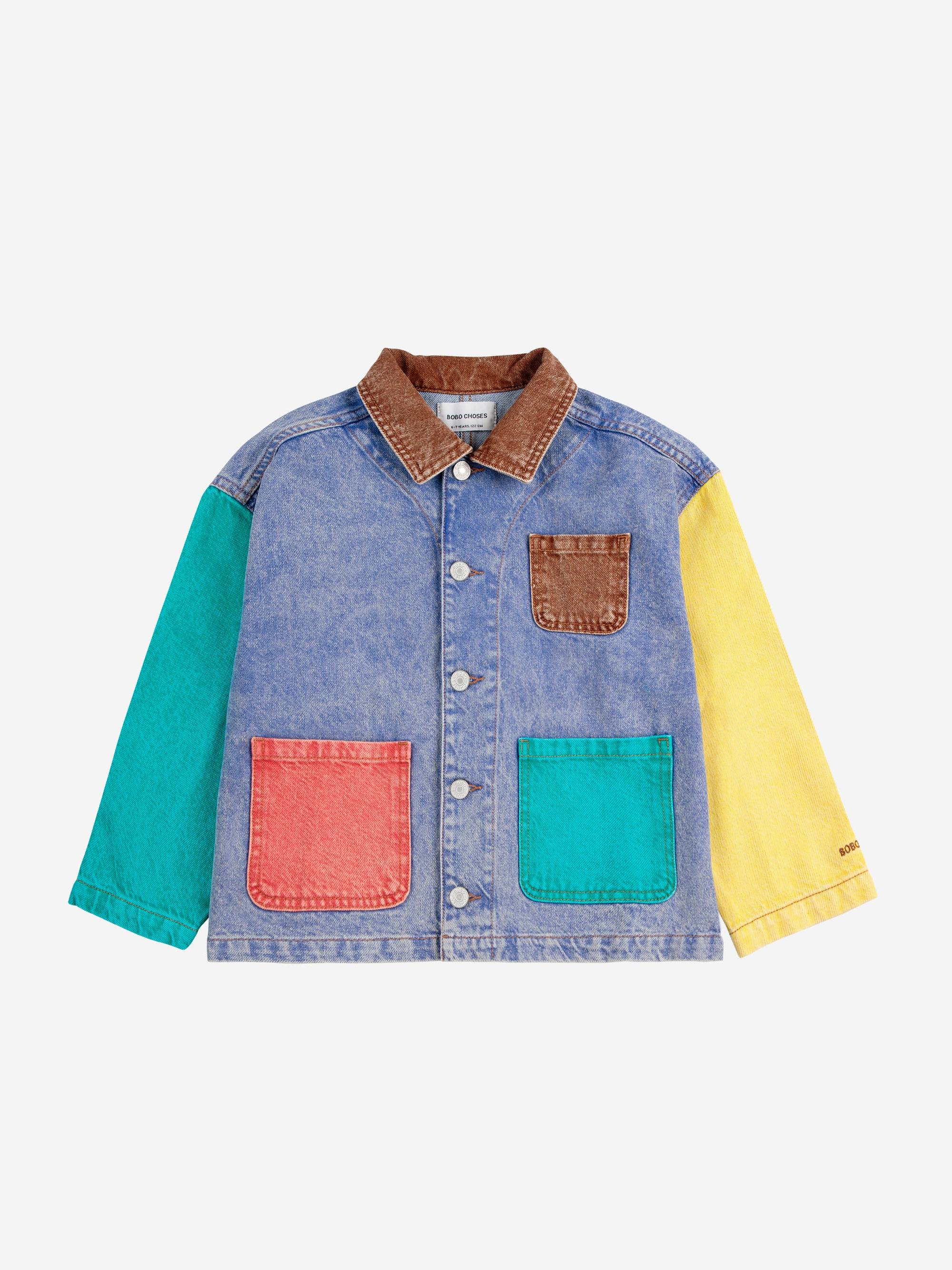 Bobo Choses Color Block Denim Jacket mit kontrastierenden Taschen in Rot, Grün und Braun sowie farbigen Ärmeln in Gelb und Türkis.