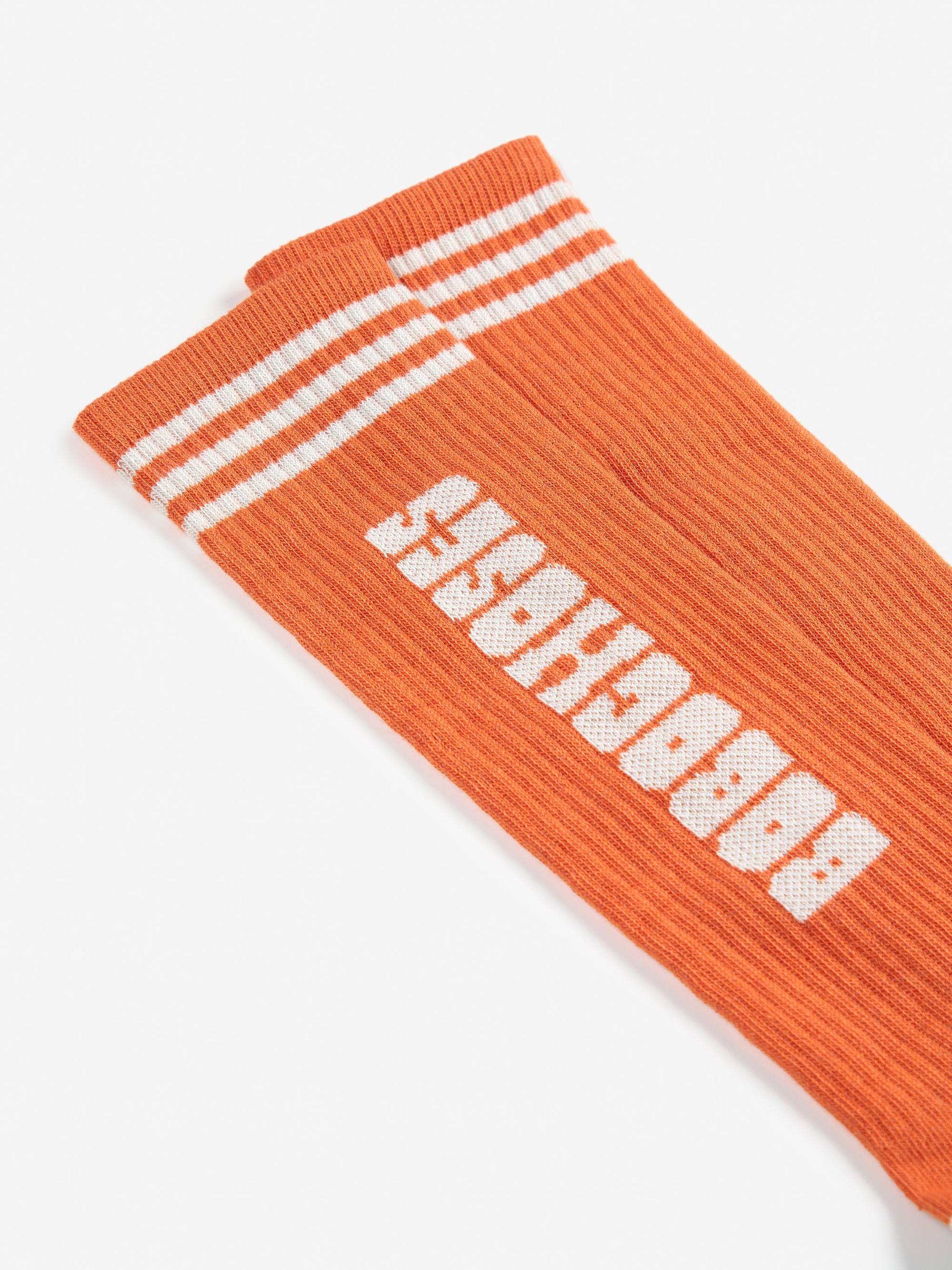 Detailansicht der Bobo Choses color block extra long socks mit weißem Logo-Schriftzug und sportlichen Streifen am Bündchen.