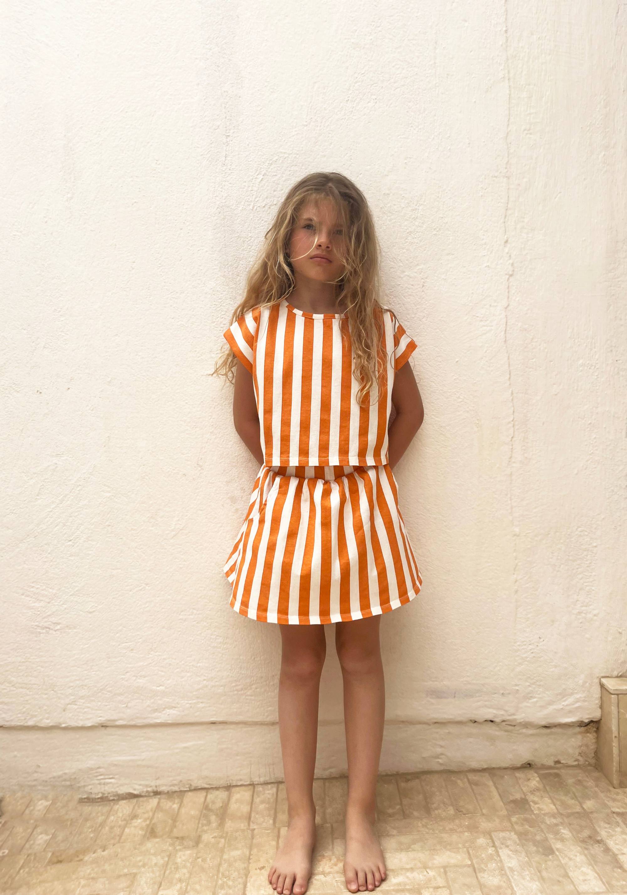 Jupe Oda Orange Stripes für Mädchen mit vertikalen orange-weißen Streifen, perfekt für Sommermode in der Kategorie Apparel & Accessories.