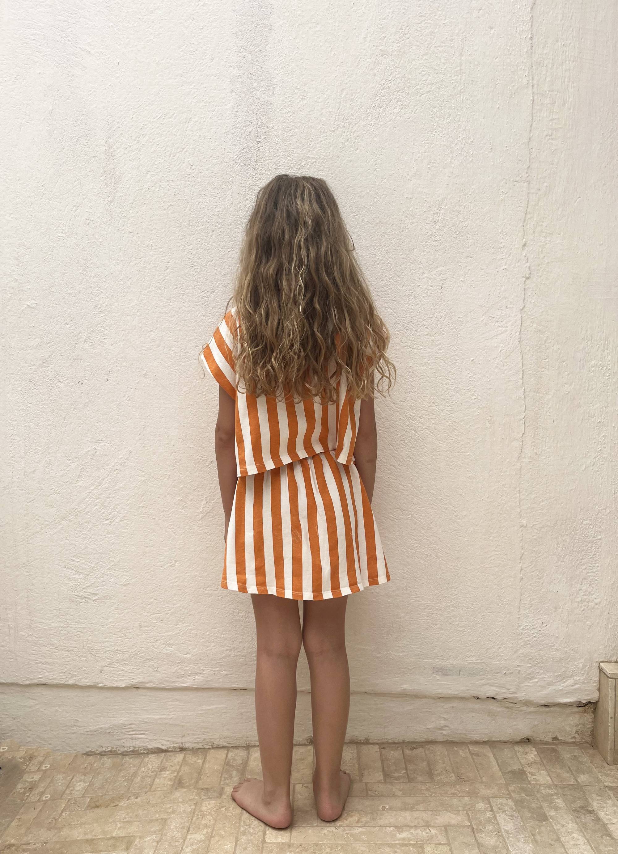 Rückansicht des Jupe Oda Orange Stripes Rocks für Mädchen mit elastischem Bund und auffälligem Streifenmuster, ideal für SS25 Kollektion.