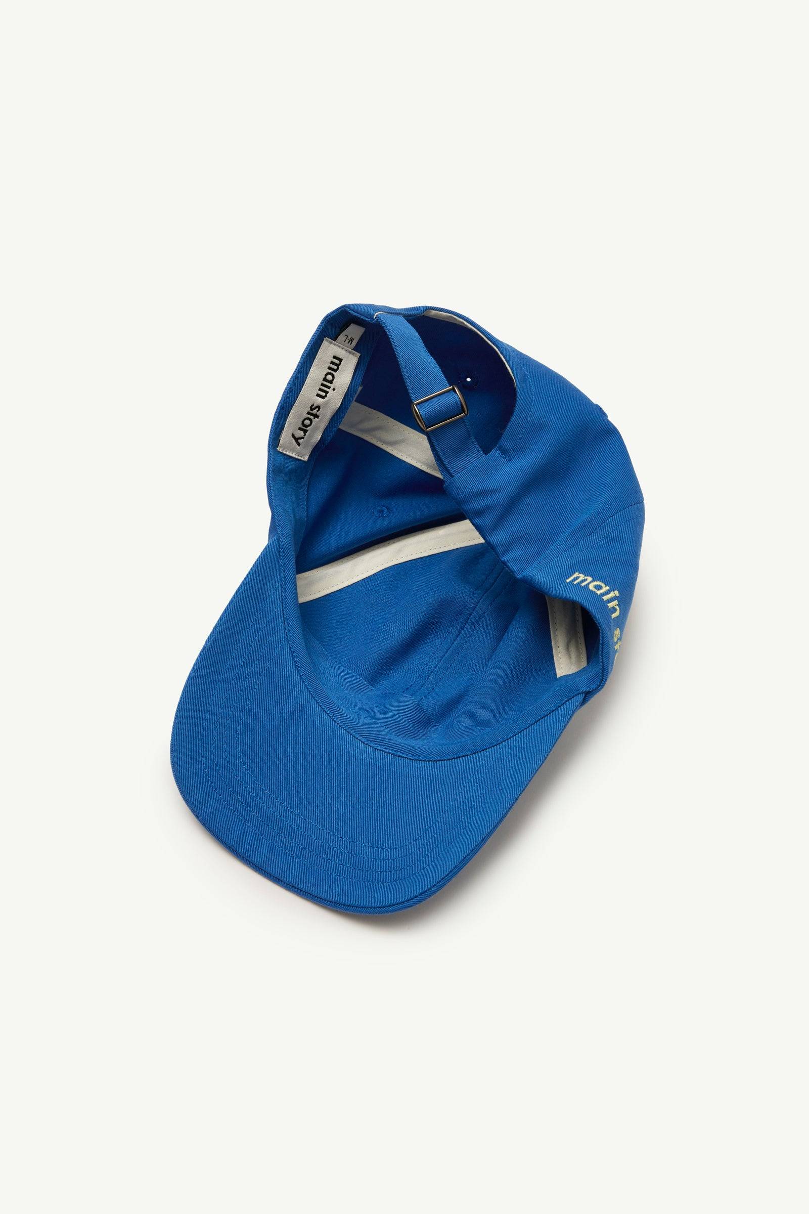 Innenansicht der Cap Blue Twill mit verstellbarem Riemen und 'main story'-Label, perfekte Passform für Kinder und Erwachsene.