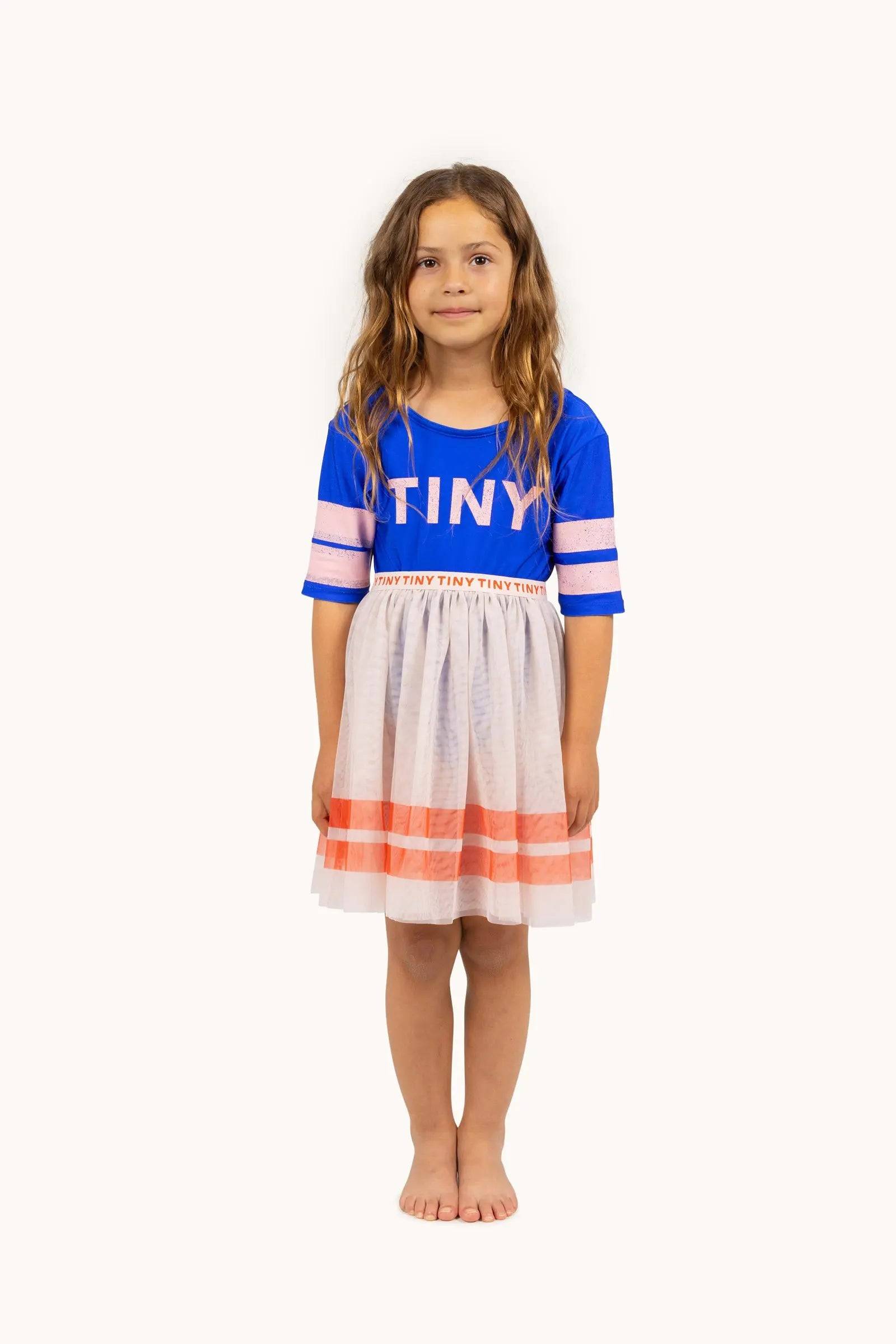 Stripes Tutu Skirt für Mädchen in Weiß mit orangefarbenen Streifen, kombiniert mit blauem T-Shirt, ideal für Frühling/Sommer-Kollektion SS25.