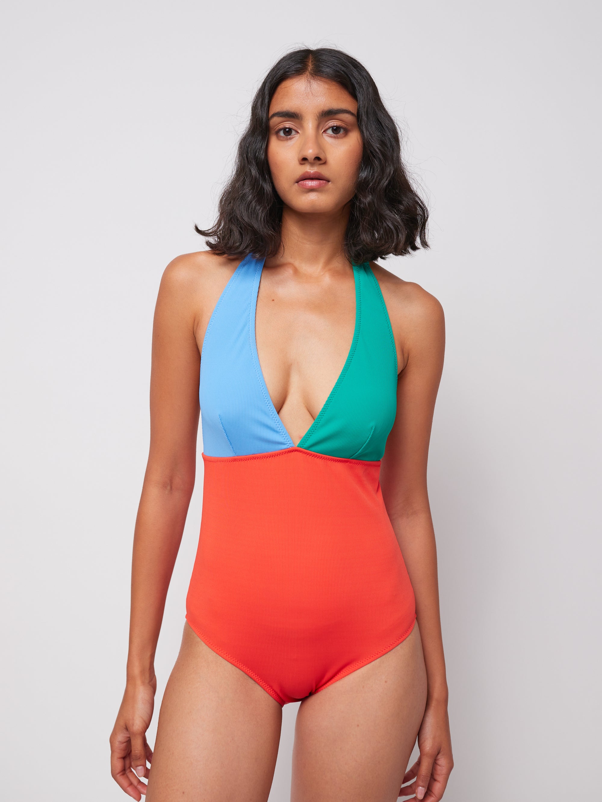 Close-up of model wearing Color Block V-Neck Swimsuit, highlighting deep V-neck and vibrant color combination.