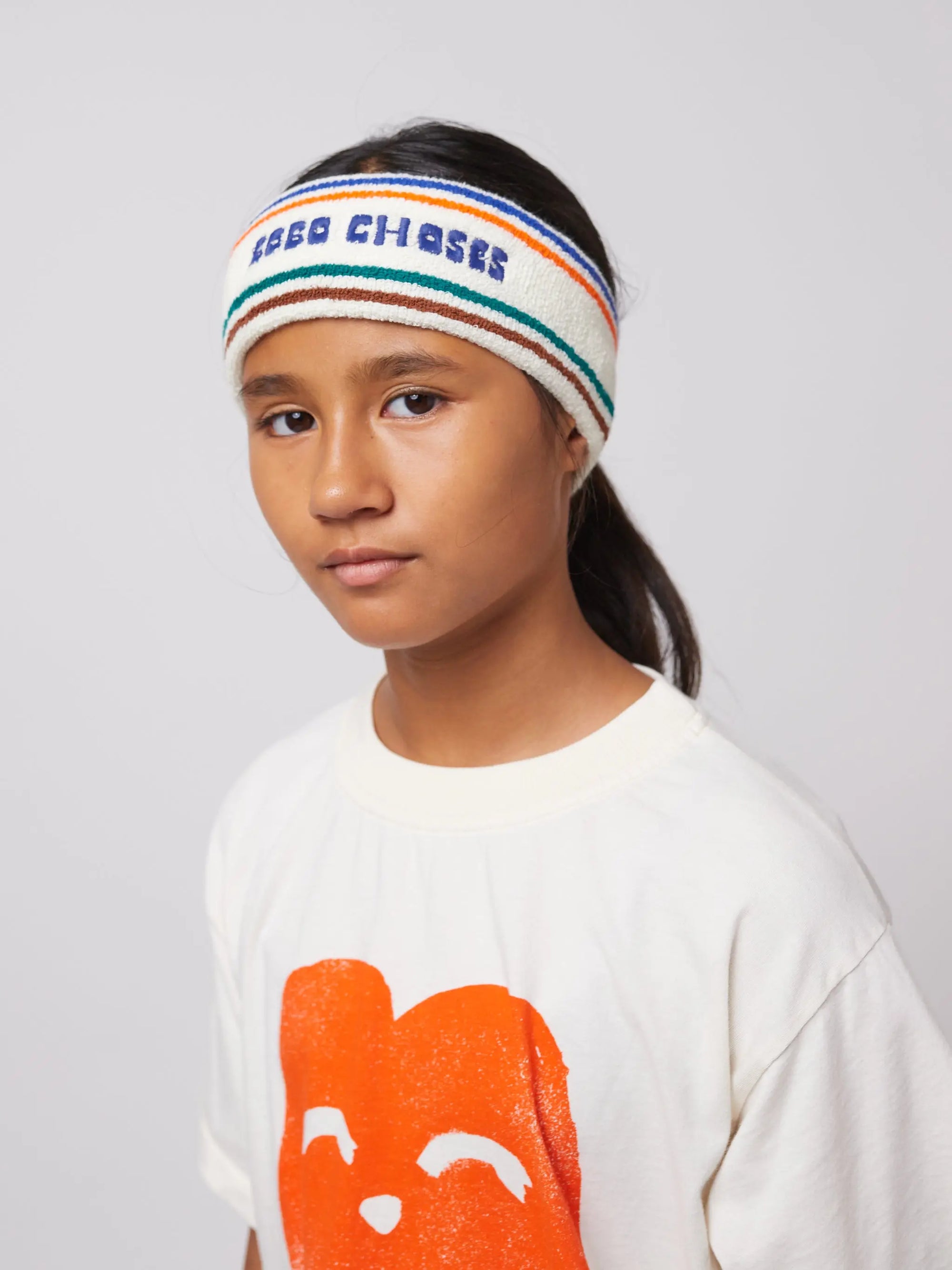 Bobo Choses Stripes Terry Headband worn by a model. Soft and stylish headband with colorful stripes and embroidered logo, perfect for any occasion.