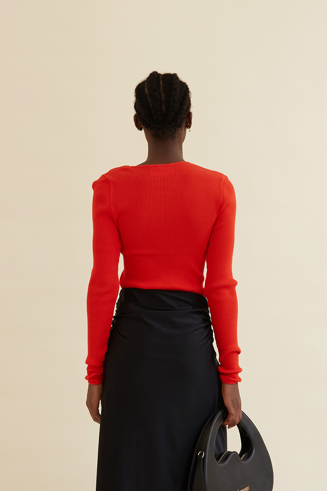 Back view of the Amèlie Seamless Top in Organic Cotton, showcasing its ribbed texture, long sleeves, and vibrant red color for a sleek, fitted look.