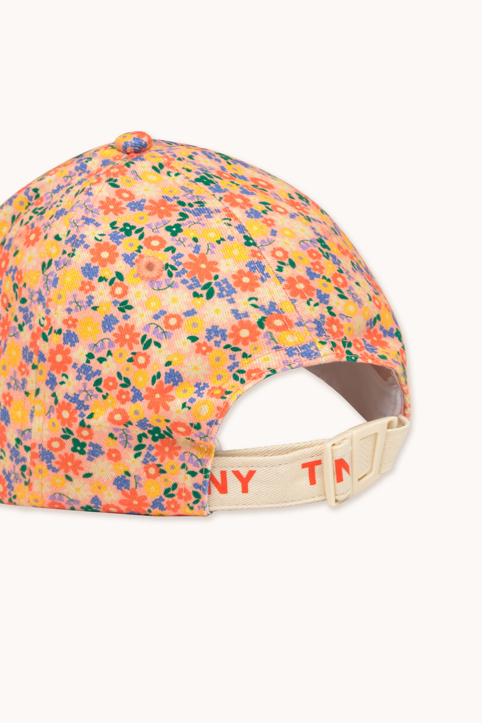 Back view of a floral garden cap with an adjustable strap featuring 'TINY' branding. Designed for a secure and comfortable fit.